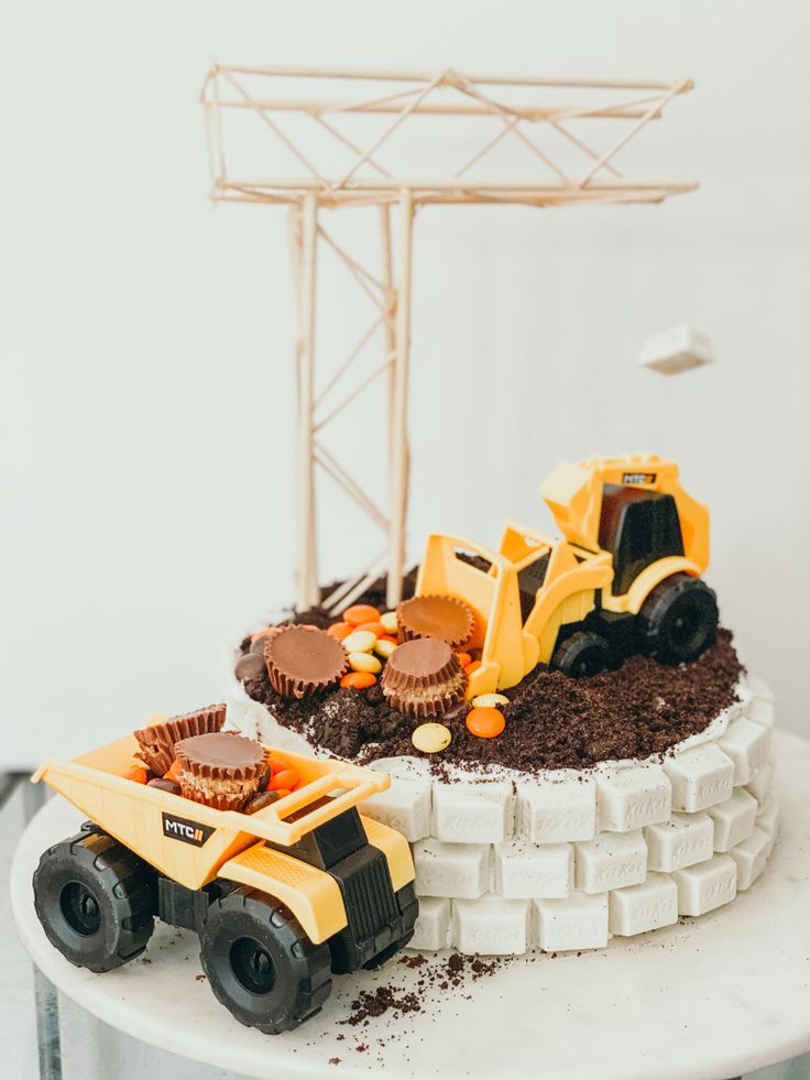 there is a cake that looks like a construction truck on top of dirt and chocolate