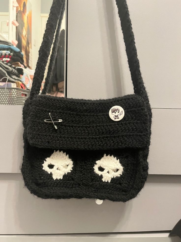 a black purse with two skulls on the front and one eyeball in the back