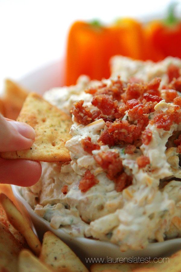 a person dipping some crackers into a bowl of dip