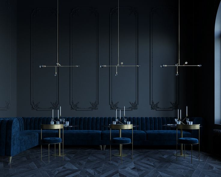 an empty room with blue velvet couches and gold tables in front of black walls