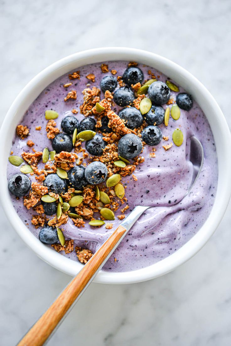 a white bowl filled with blueberries and granola