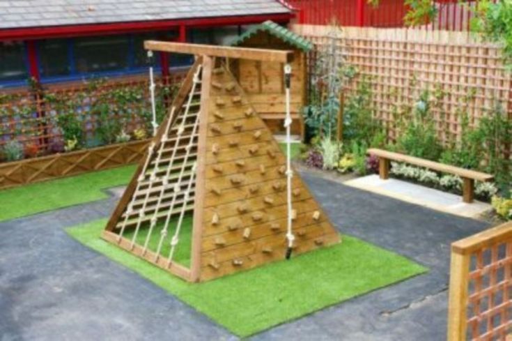 a wooden play structure in the middle of a yard