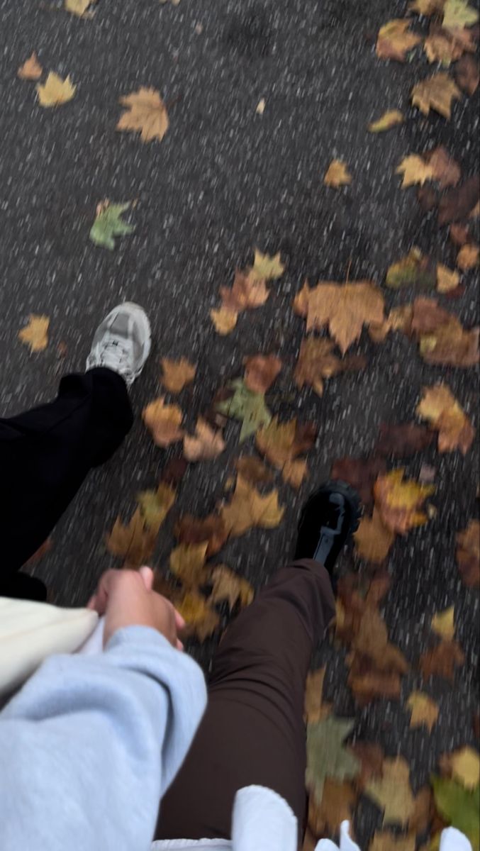 two people standing in the rain with their feet up