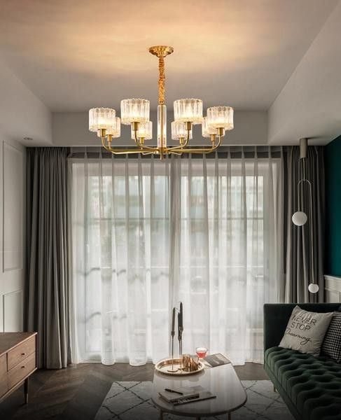 a living room filled with furniture and a chandelier hanging over the top of a coffee table