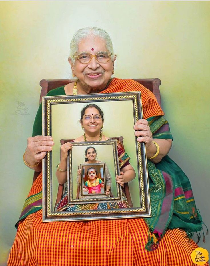 an old woman holding up a framed photo