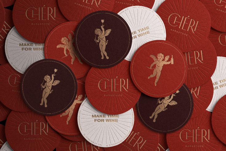 many red and white paper coasters with gold foil designs on the front, surrounded by smaller ones