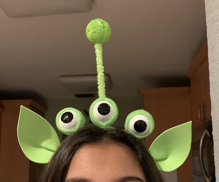 a woman with long hair wearing green monster ears and eyeballs on top of her head