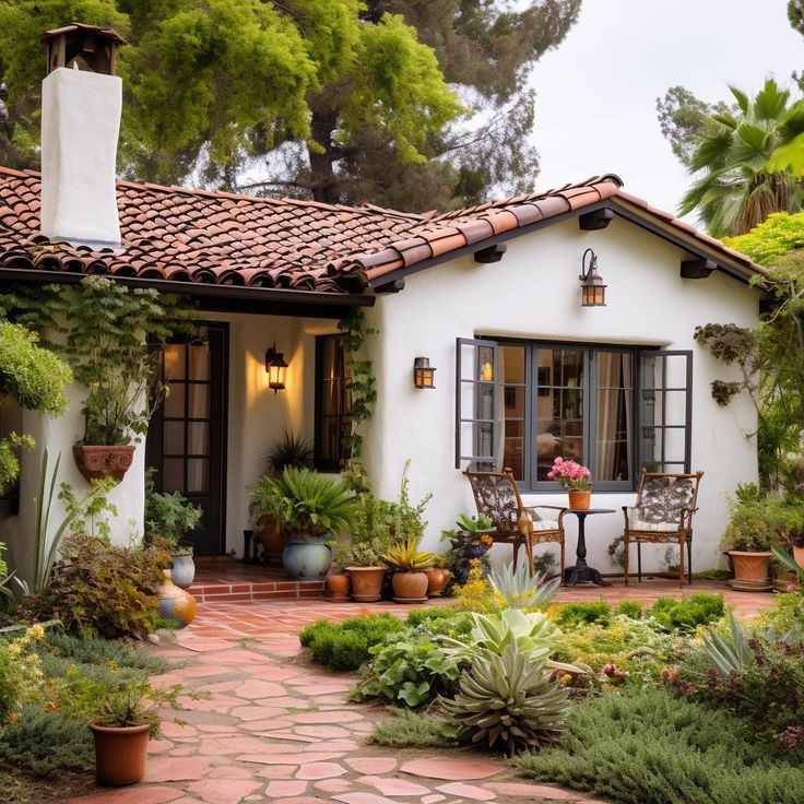 a small white house with lots of greenery and potted plants on the front