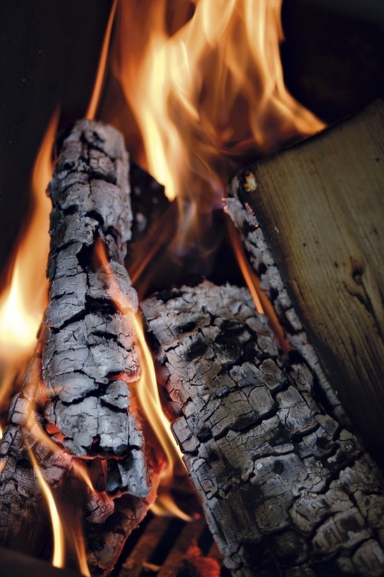 the fire is blazing in the fireplace and it looks like wood has been chopped up