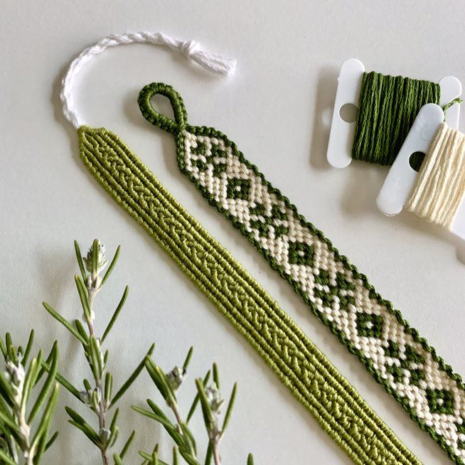 two green and white beaded bracelets next to spool of thread