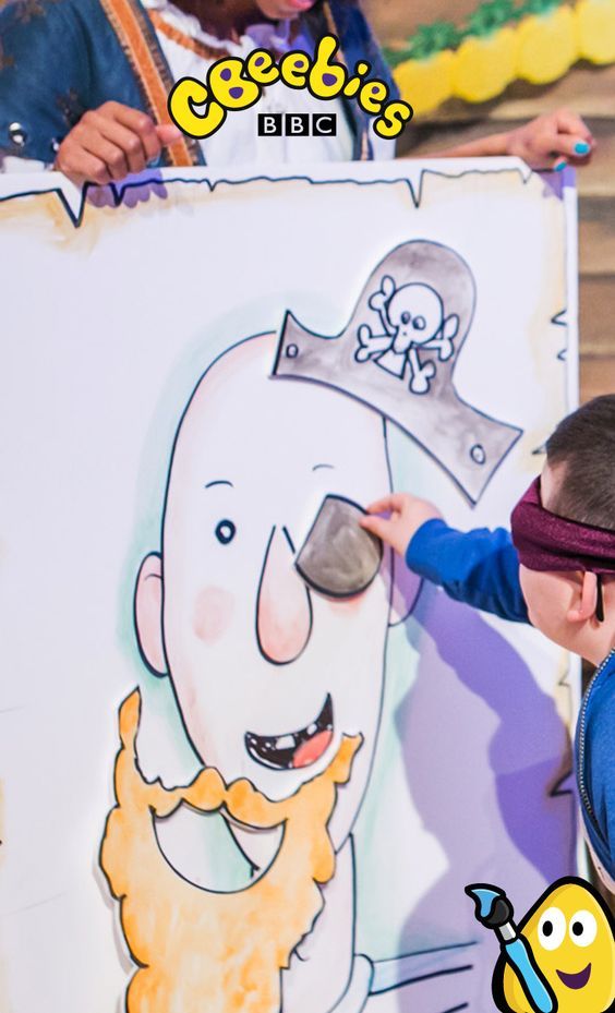 a young boy is drawing on a large poster with his face as if he's wearing a pirate hat