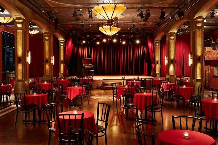 an empty restaurant with red tablecloths and chairs