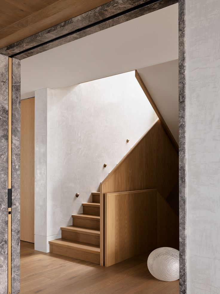 the stairs are made of wood and have white walls