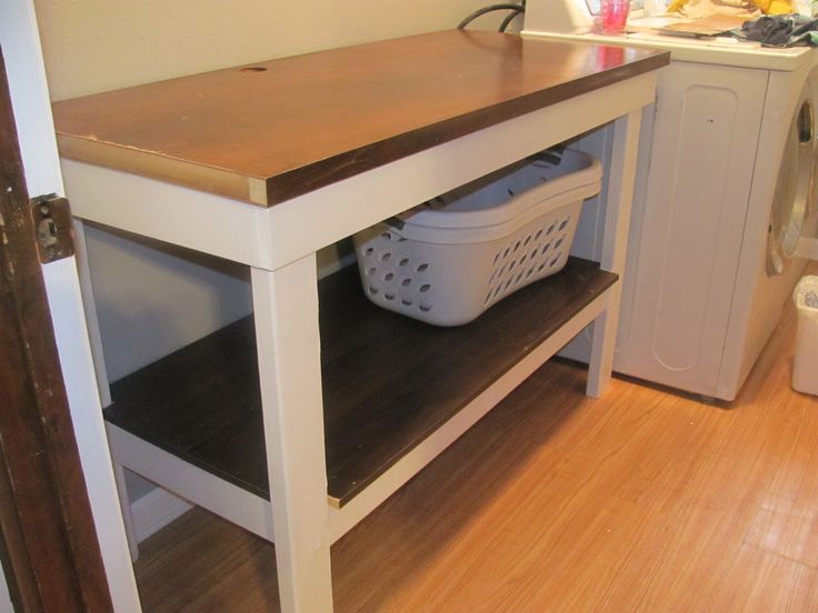 a white washer and dryer sitting on top of a wooden shelf in a laundry room