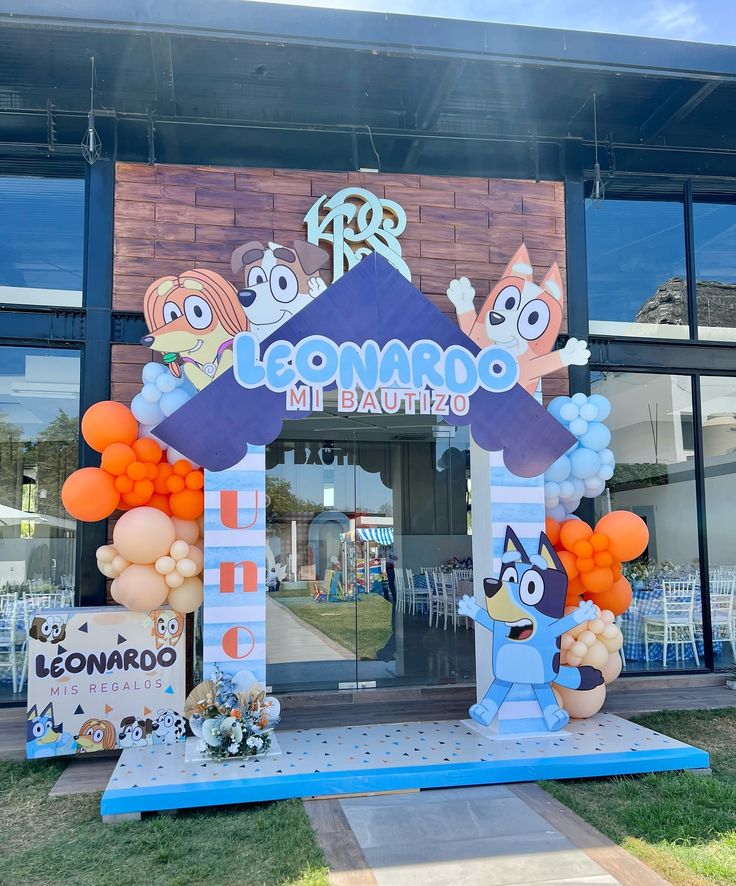 the entrance to an ice cream parlor decorated with balloons and cartoon character decorations for it's birthday party