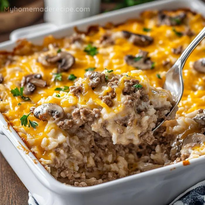 a casserole dish with meat and mushrooms in it being spooned out by a fork