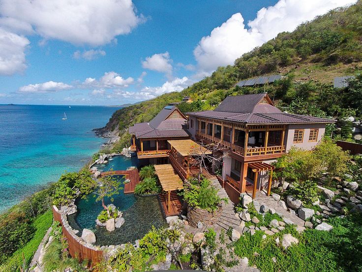 an aerial view of a house on the ocean