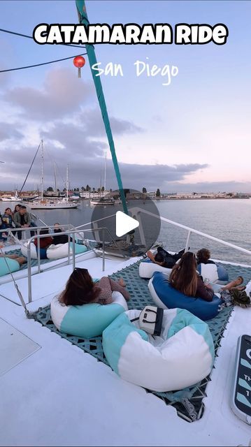 people are sitting on bean bag chairs on the deck of a boat in the water