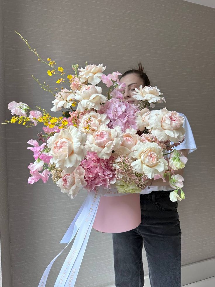 a woman holding a large bouquet of flowers