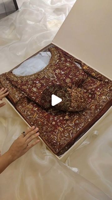 two women are working on an intricately designed piece of cloth that is being sewn together