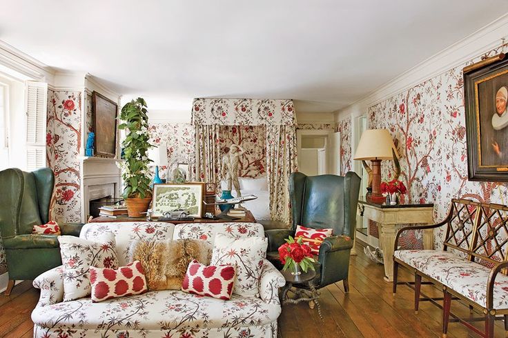 a living room filled with furniture and wallpaper covered in floral designs on the walls