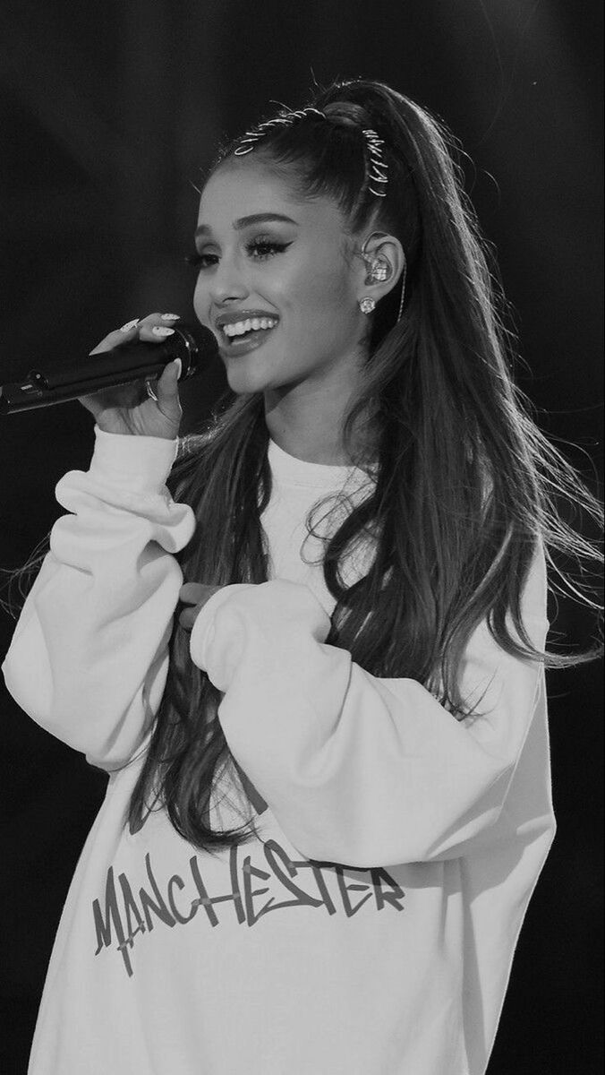 a black and white photo of a woman with long hair wearing a sweatshirt that says manchester