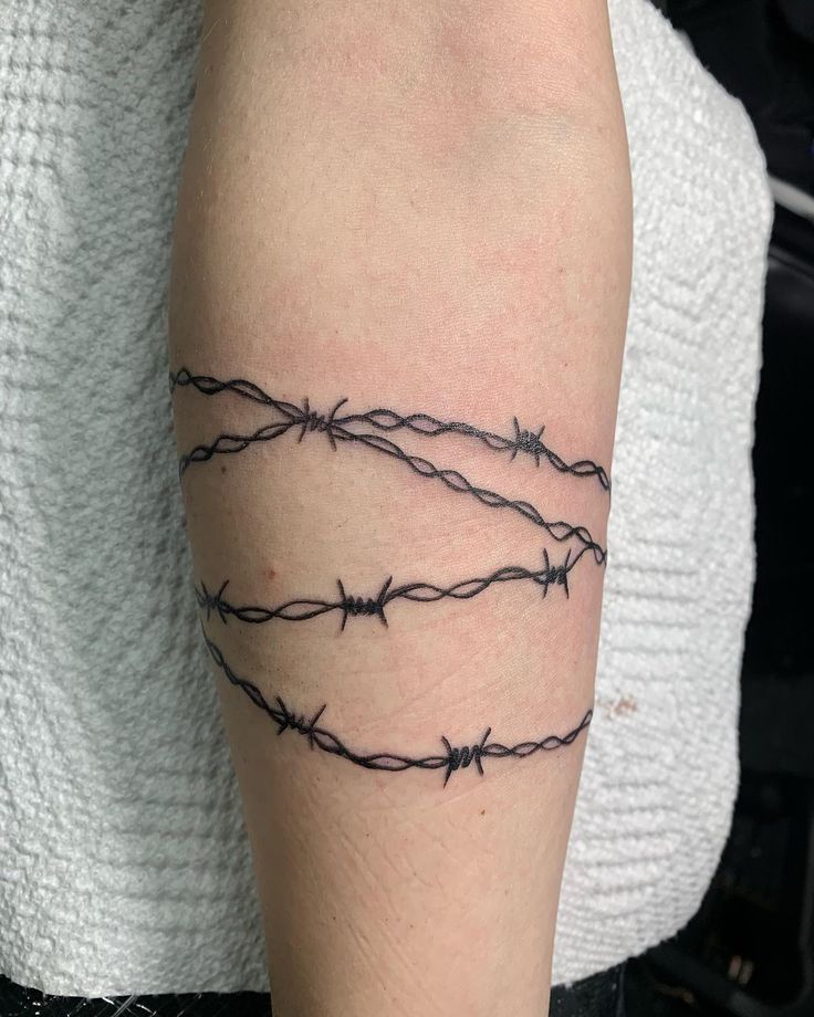 a tattoo with barbed wire on the arm