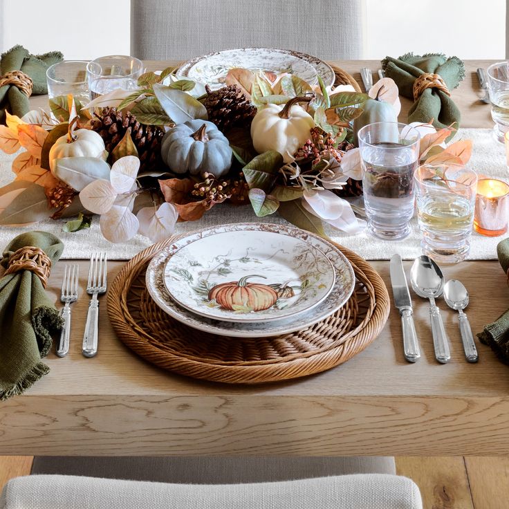 a wooden table topped with plates and silverware