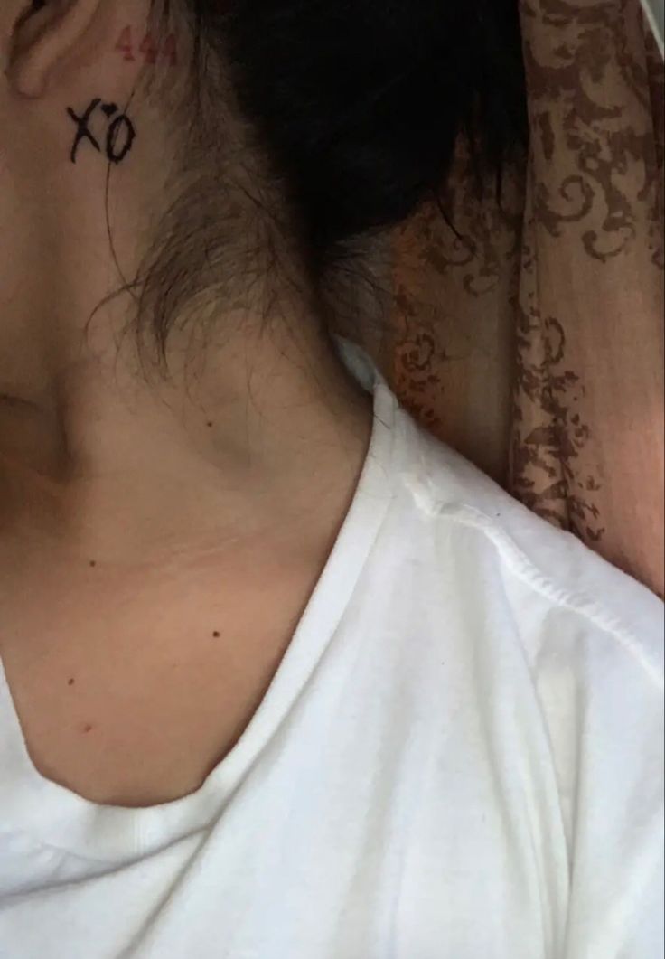 a woman with a cross tattoo on her neck