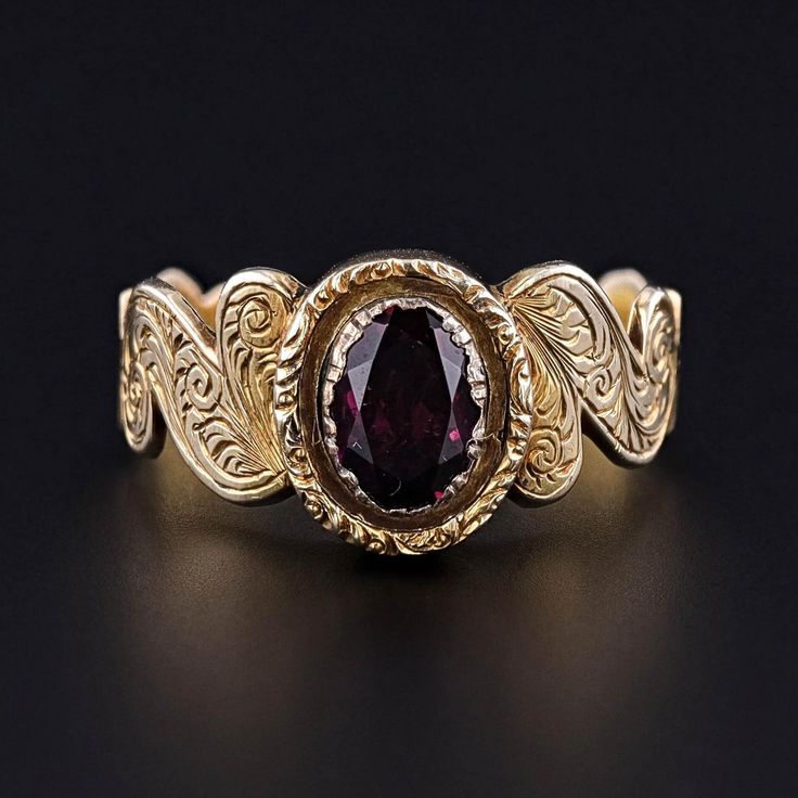 This Victorian era, antique ring (circa 1860-1870) features a rhodolite garnet set in hand engraved 9ct gold. The inside of the band bears the initials 'JY'.  The ring is a size 9.5, but it can be re-sized free of charge.  It is in excellent condition; however, the garnet is a later replacement and not original to the ring.  We have many other fantastic offerings of antique and vintage jewelry posted on our Etsy store, so please consider browsing our other items. We send all items in individually packaged gift boxes and offer layaway plans! + Trademark Antiques Shop Homepage https://www.etsy.com/shop/TrademarkAntiques + Our Store Policies https://www.etsy.com/shop/TrademarkAntiques/policy?ref=shopinfo_policies_leftnav + Connect with us on Social Media (Get access to monthly giveaways, spec Antique Garnet Promise Ring, Antique Hallmarked Ruby Signet Ring, Victorian 14k Gold Ruby Ring With Intricate Design, Antique Ruby Signet Ring, Vintage Garnet Ruby Ring With Intricate Design, Antique 14k Gold Ruby Ring With Intricate Design, Victorian 14k Gold Ruby Ring, Victorian Yellow Gold Ruby Ring With Intricate Design, Victorian Style 14k Gold Ruby Ring