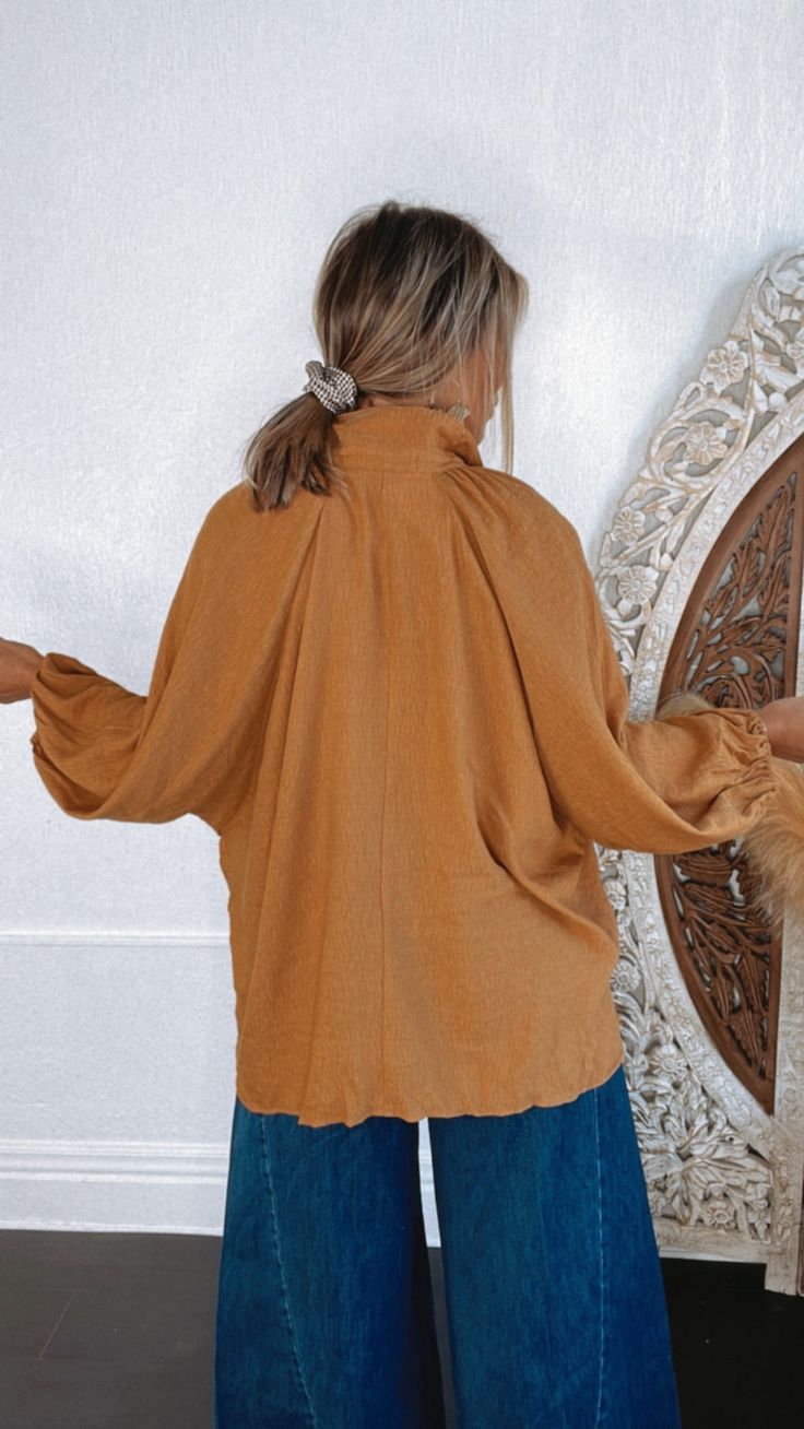 Seasonal bliss, this dolman style blouse is featured in an oversized, slouchy fit with classic button-front neckline and a rich camel color tone creating the ideal fall blouse. Neckline: Button up with collar Fabric: 80% Rayon, 20% Nylon Details: Oversized fit, cuffed long dolman sleeve, button up bodice Imported Fit: Oversized! - Arms: Relaxed - oversized dolman style Model Specs: Karli is wearing a size s/m in the photo. How will this item fit you? Check out our MODEL SPECS (Typical Sizing - Karli: S-Size 5/26 - 5ft 2in, Emily: S-Size 3/25 - 5ft 5in, Syd: L/XL- Size 15/ - 5ft 8in)Need help with sizing? No problem! Join our VIP group on Facebook, Everyday Chic Boutique VIP Insiders to chat directly with our team and other customers just like you.Packaged with love and shipped from our war Blouse Neckline, Fall Blouse, Vip Group, Everyday Chic, Vintage Fall, Style Blouse, Color Tone, Holiday Looks, Camel Color