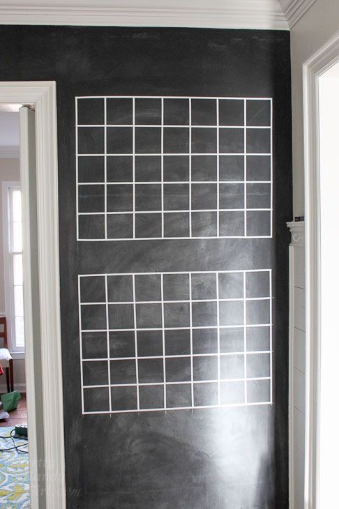 a chalkboard with squares drawn on it in a room next to a door and carpet