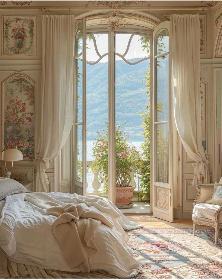 a bedroom with an open window overlooking the water