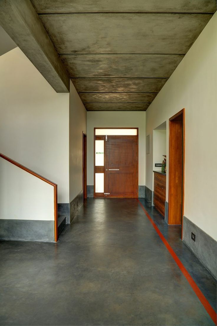 an empty hallway with wooden doors and railings on both sides, leading to the second floor