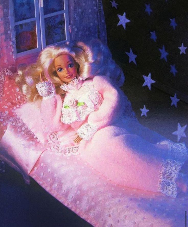 a barbie doll is laying on a pink bed with white stars in the night sky