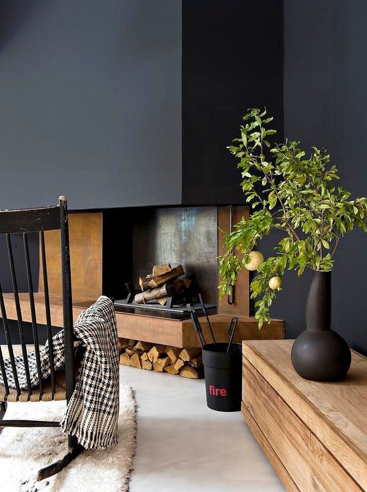 a living room filled with furniture and a potted plant next to a fire place