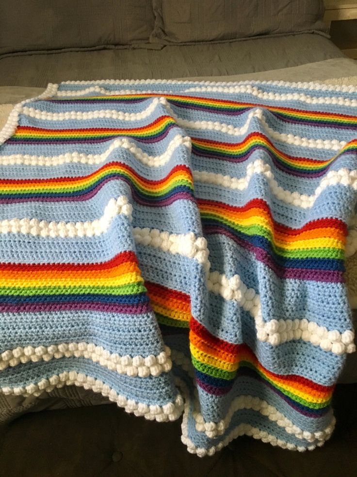 a crocheted blanket is laying on a couch