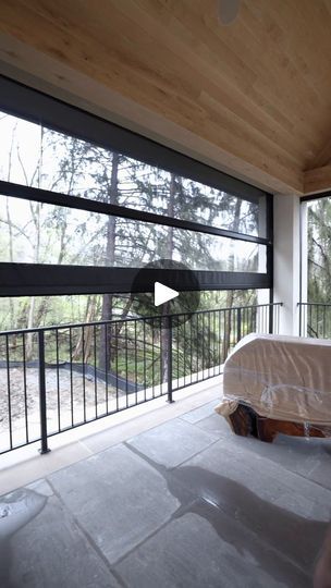 a bedroom with large windows and a bed on the floor next to a balcony area