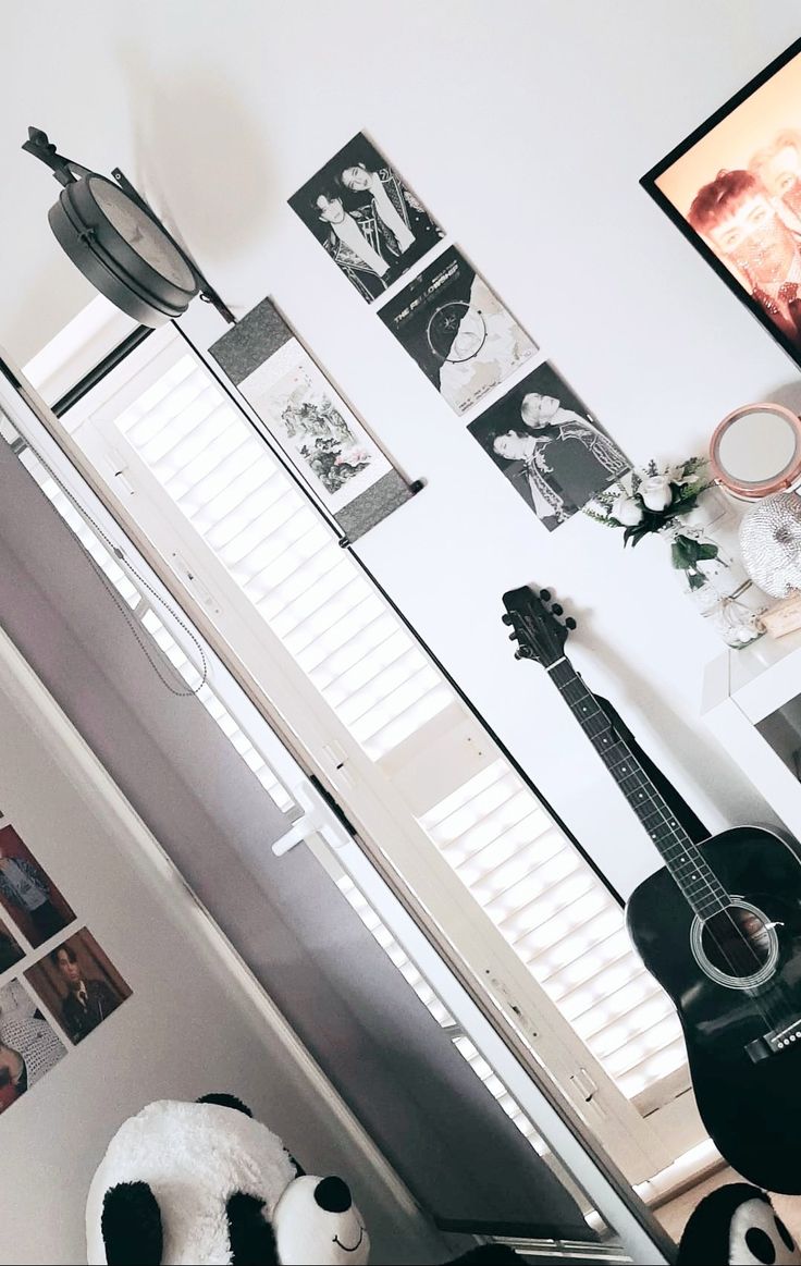 a living room with a guitar and pictures on the wall above it's head