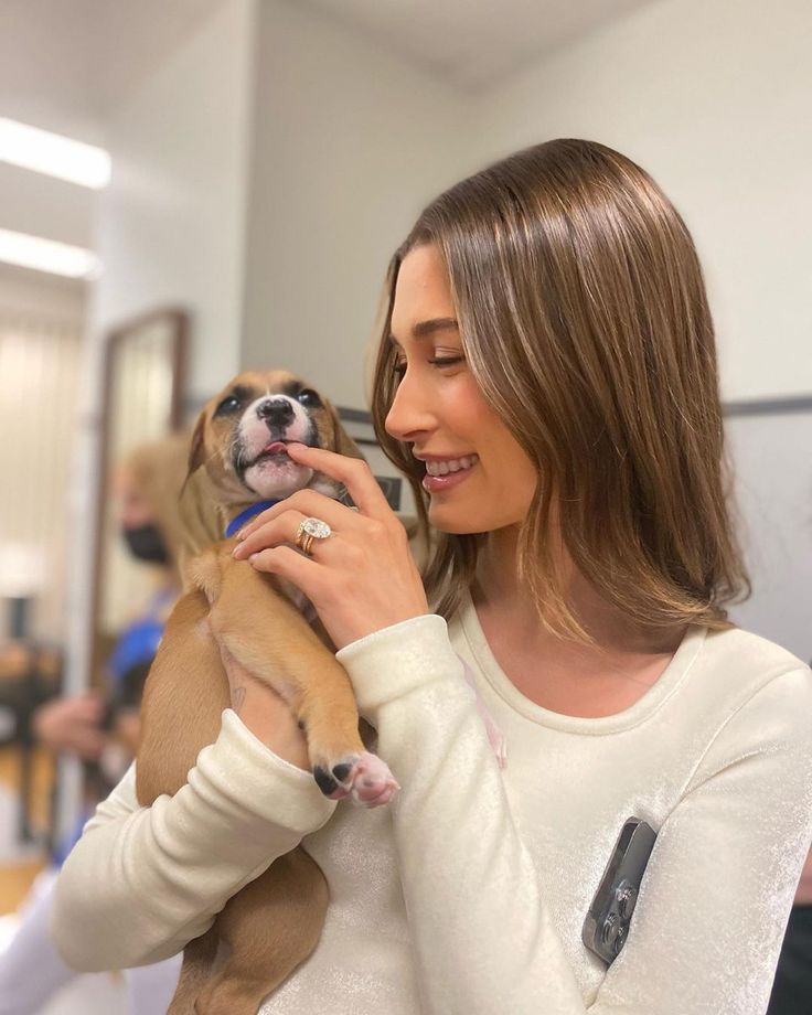 a woman holding a small dog in her arms and looking at it's face