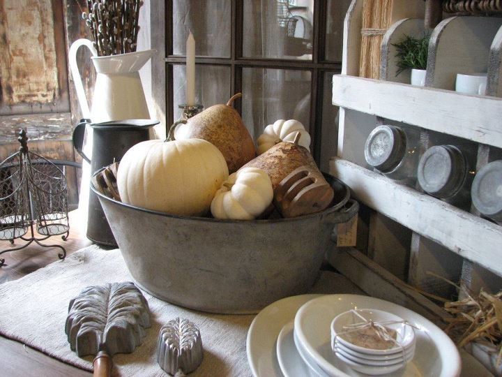 a metal bowl filled with lots of different types of pumpkins and gourds