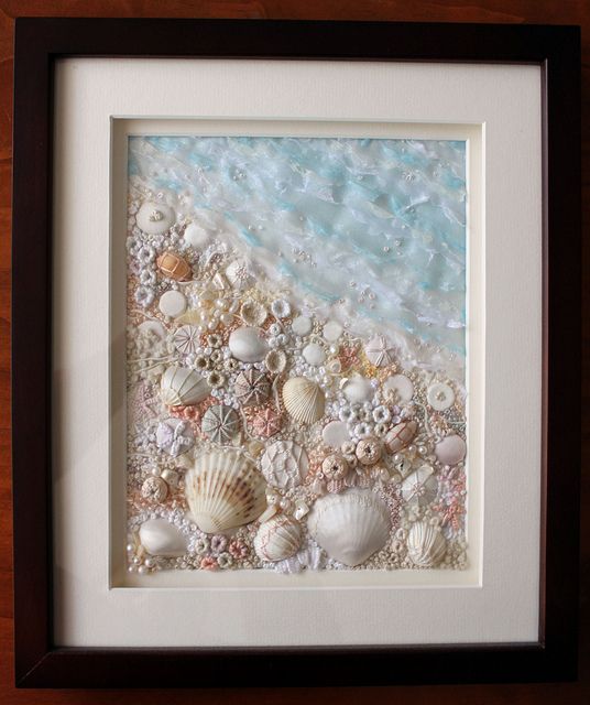 an image of seashells on the beach framed in a wooden frame