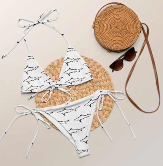 Stay comfortable and stylish all summer with this Shark Print String Bikini set. It's made from soft recycled polyester with double-layering and UPF 50+. Style the straps how you like, and get ready to swim!  * Soft and stretchy material with UPF 50+ * Bikini top comes with removable padding for comfort * Multiple ways to tie and style the bikini set To make your All-Over Print Recycled String Bikini last longer, thoroughly rinse it off after each use and get rid of any chlorine/salt residue. At Adjustable Beachy Swimwear For Vacation, Beachy Adjustable Swimwear For Vacation, Adjustable Swimwear For Beach Party Vacation, Adjustable Swimwear For Pool Vacation, Adjustable Swimwear For Poolside And Beach, Adjustable Swimwear For Poolside And Beach Season, Adjustable Tie-side Swimwear For Vacation, Adjustable Tie-side Bottom Swimwear For Vacation, Adjustable Swimwear For Vacation