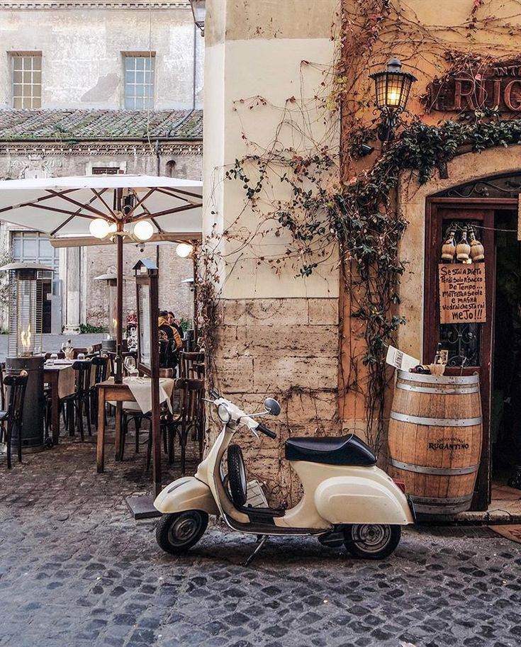 a motor scooter parked in front of a building with vines growing on it