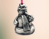 a silver ornament with a red candle in the shape of an elephant holding a scarf