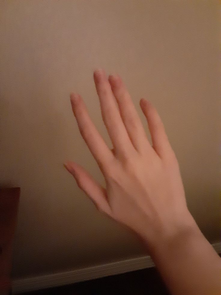 a person's hand reaching up against a wall