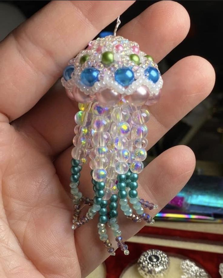 a hand holding a beaded necklace in it's palm