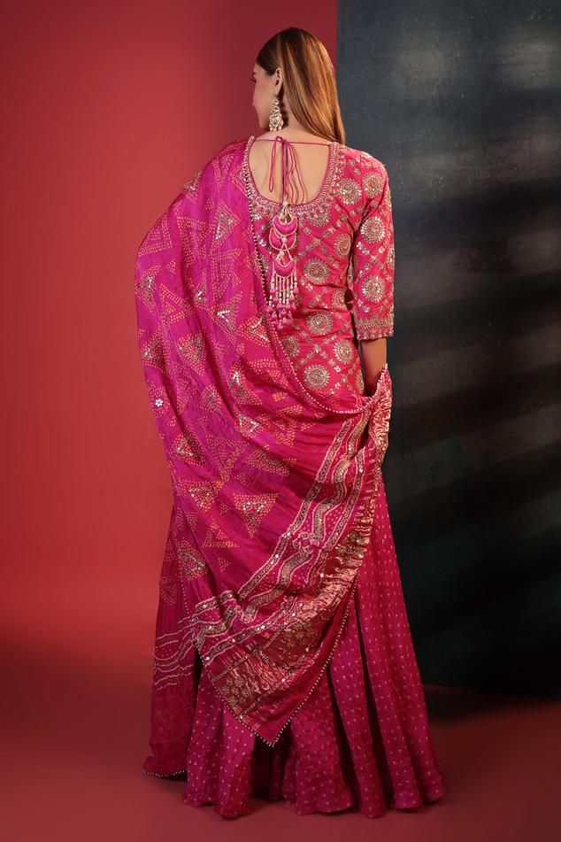 Pink kurta with gota patti, mirror embroidery in floral and checkered pattern. Paired with bandhani woven sharara and dupatta.
Components: 3
Pattern: Embroidery, Woven
Type Of Work: Gota patti, mirror, floral, checkered
Neckline: U neck
Sleeve Type: Three quarter
Fabric: Silk
Color: Pink
Other Details: 
Bead embellished bordered dupatta
Back tassel tie-up
Attached lining
Length:
Kurta: 36 inches
Sharara: 42 inches
Disclaimer: These are made to order designer styles, hence expect a slight variati Diwali Bandhani Print Semi-stitched Sharara, Pink Bandhani Print Sharara For Party, Pink Bandhani Print Sharara For Wedding, Semi-stitched Multicolor Sharara With Bandhani Print, Pink Bandhani Print Fitted Sharara, Bandhani Sharara, Pink Kurta, Mirror Embroidery, Sharara Set