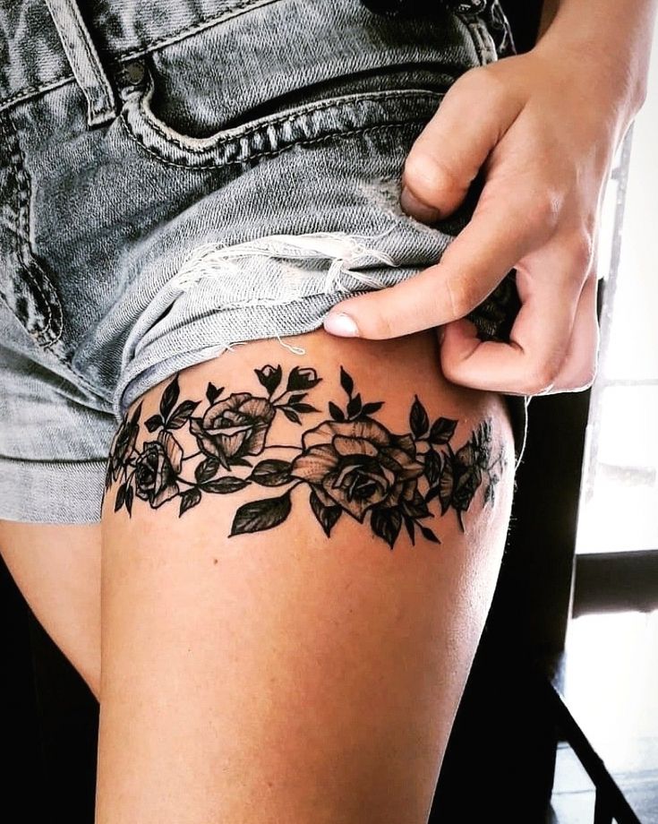 a woman is showing off her thigh with flowers on it and the bottom half of her leg