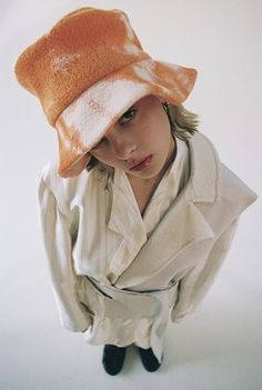 a young woman wearing a hat and trench coat